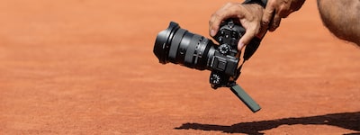 Usage image of a man crouching and holding the camera to shoot close to the ground