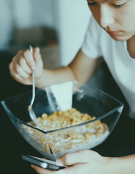 Person eating while looking at their phone