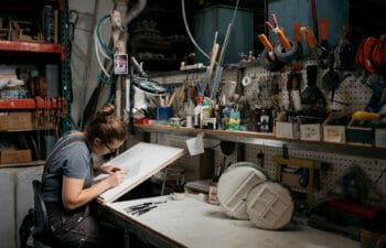 Tilemaker working at a workbench in a studio.