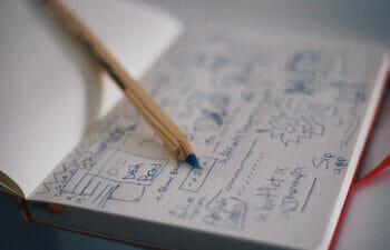 Open notebook with storyboard notes and pen