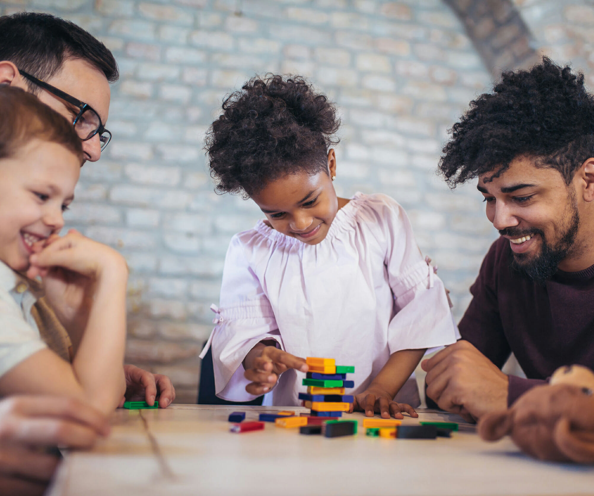 Two fathers play educational games with their children