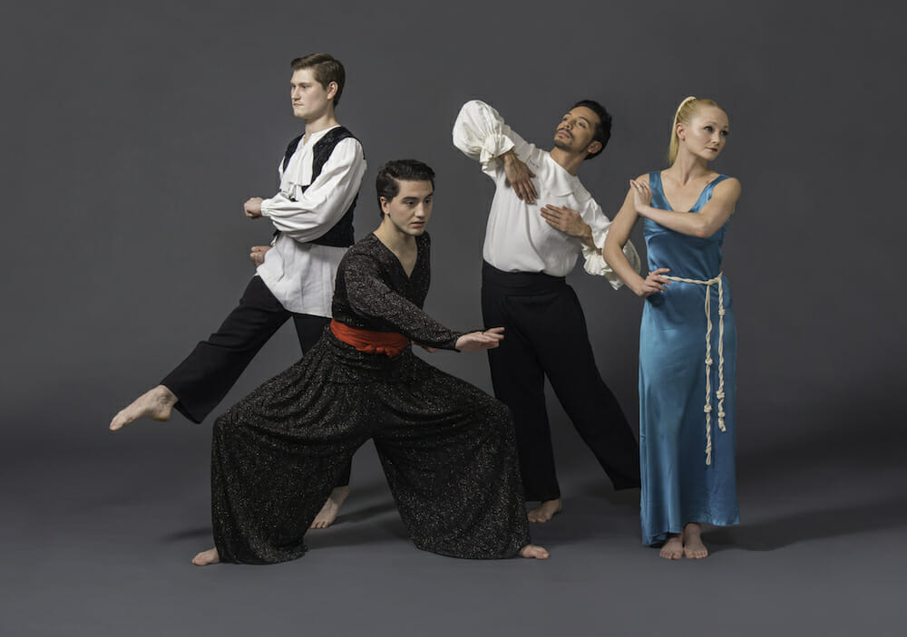 Four dancers in bright costumes pose in a line