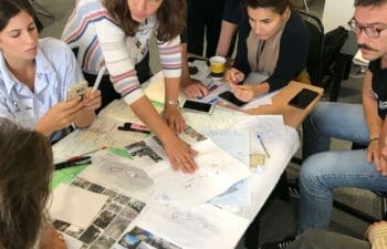 Group around table looking at photos and maps