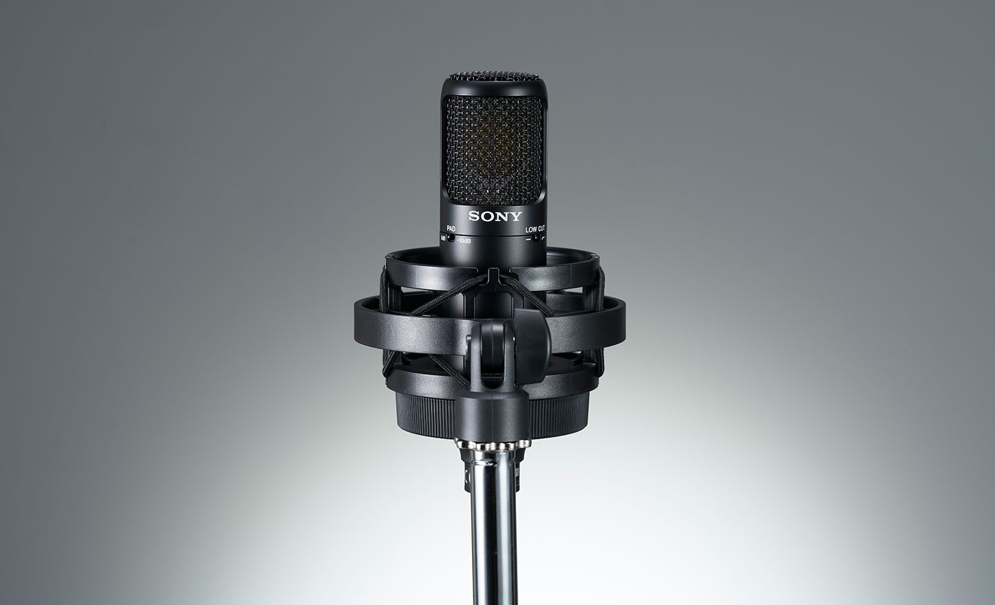  Image of the front of the Sony C-80 Uni-directional condenser microphone in its stand on a grey background