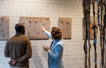 Two people looking at artwork in a gallery