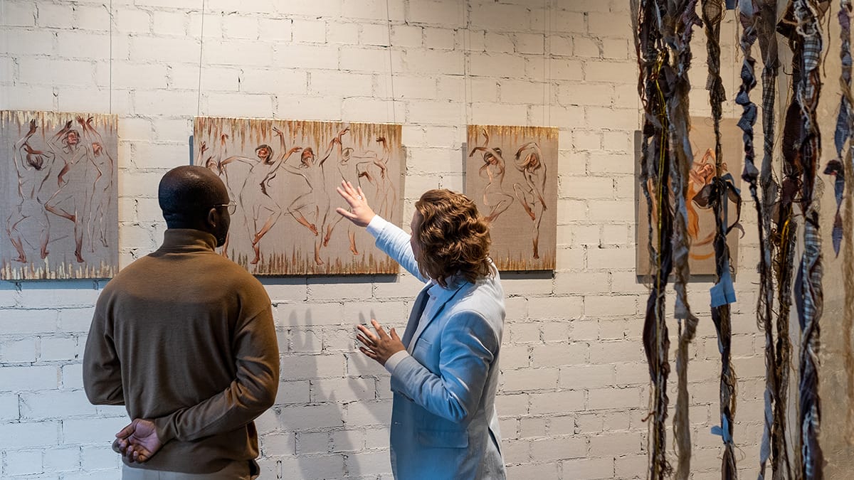 Two people looking at artwork in a gallery